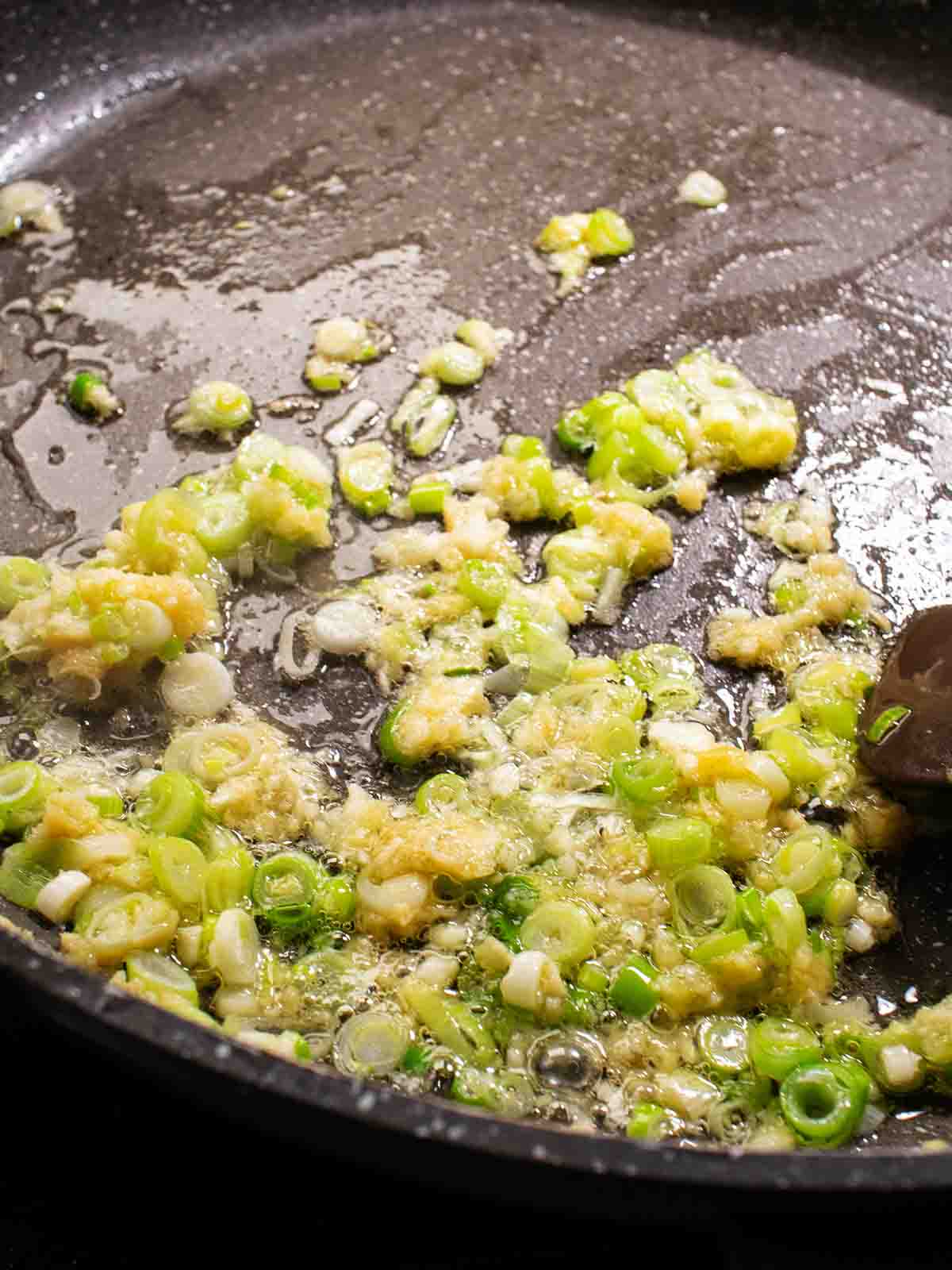 scallion, ginger and garlic sauteed in a pan with oil