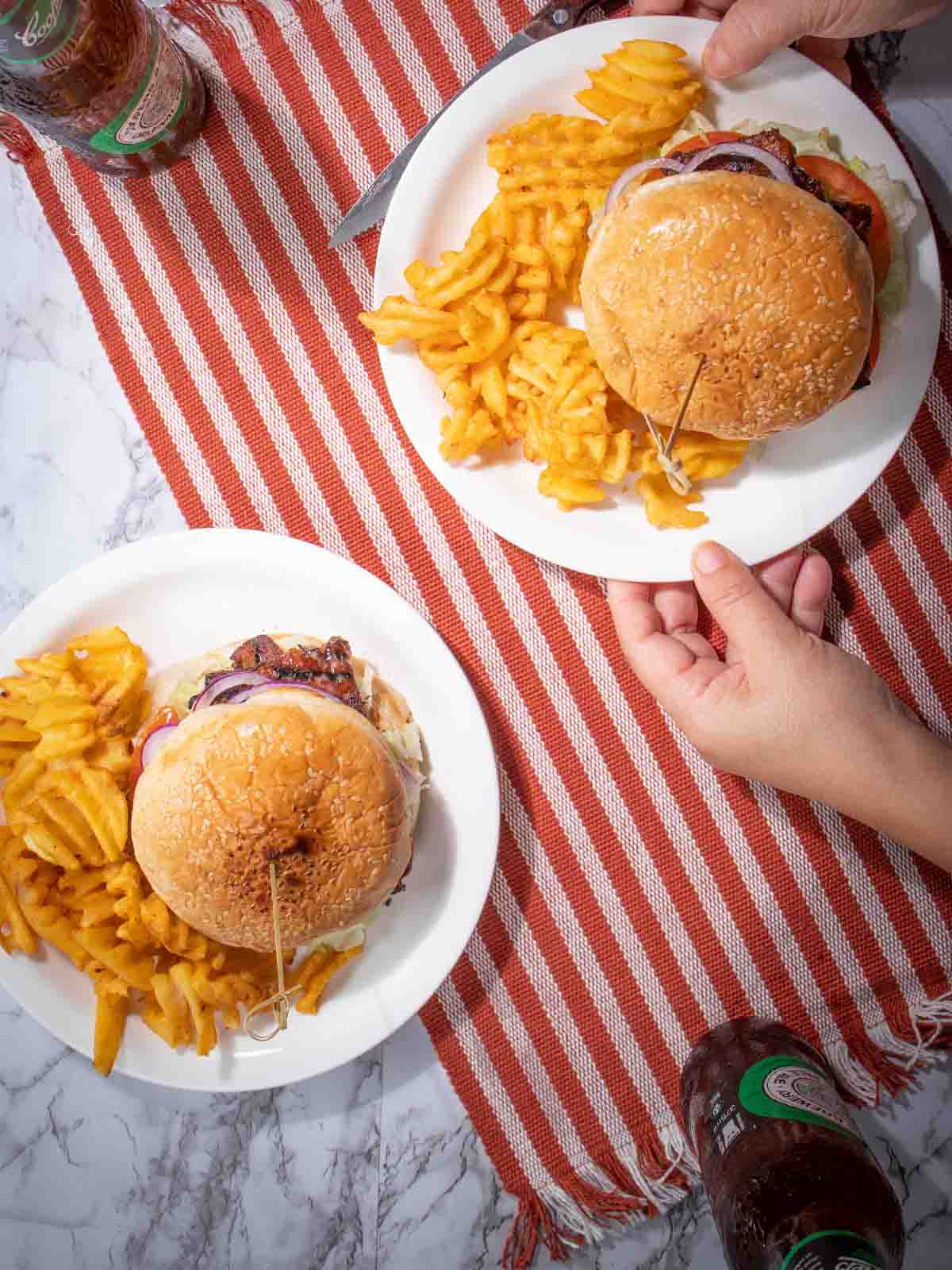 two plates of burger and chips