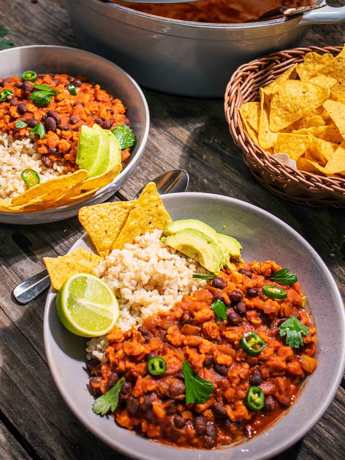 two bowls of vegan chilli with corn chips