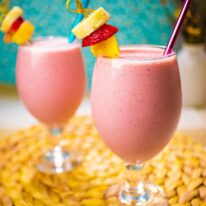 two glasses of tropical smoothie with fresh fruits
