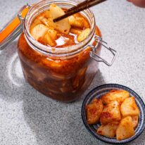 dish out pickled daikon from a jar by chopsticks