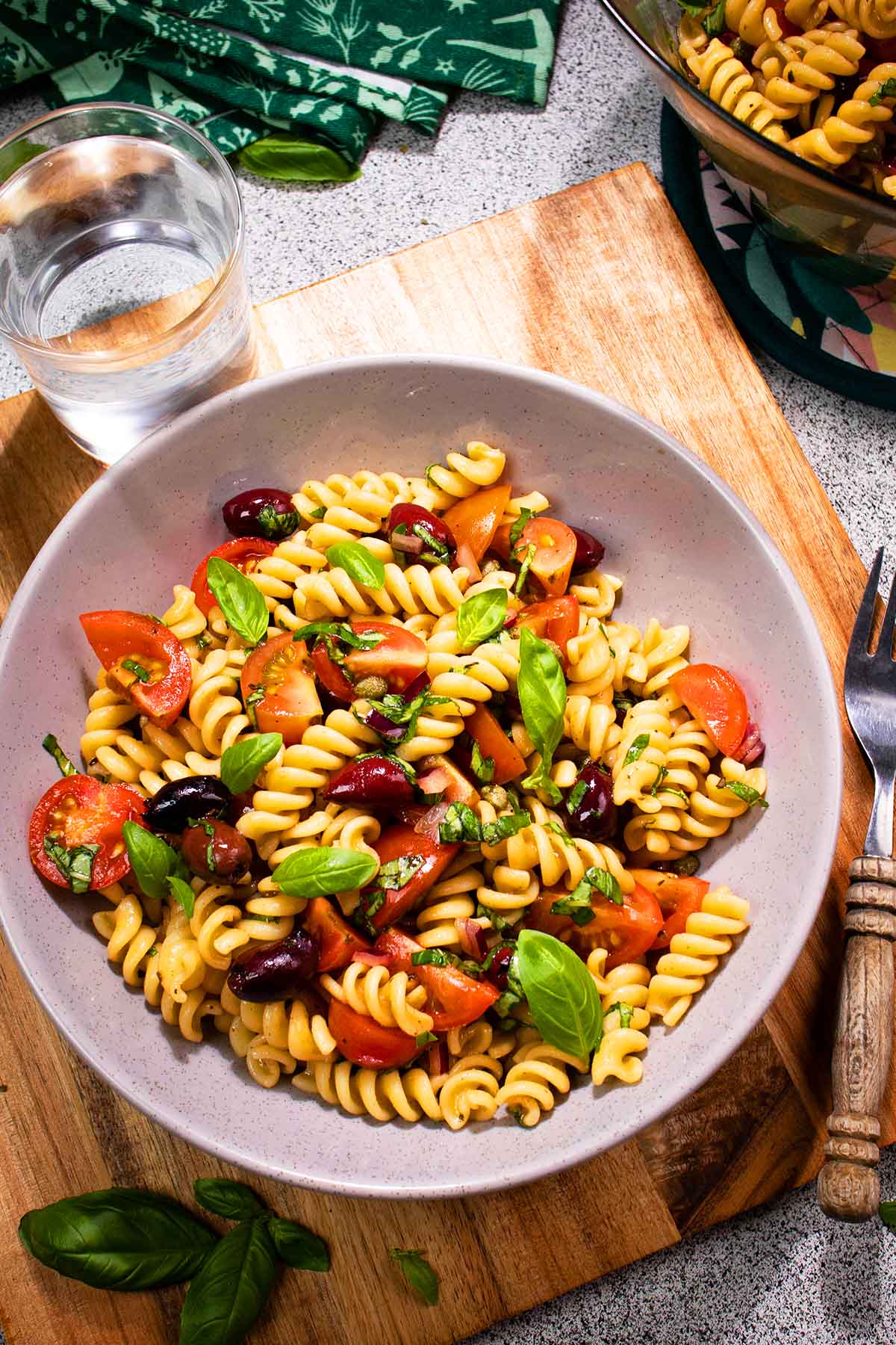 a bowl of italian pasta salad on the table