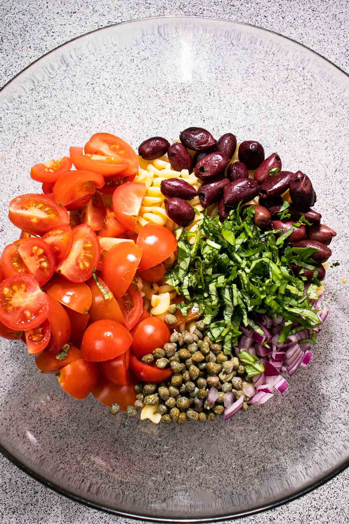 prepare ingredients in a mixing bowl for pasta salad